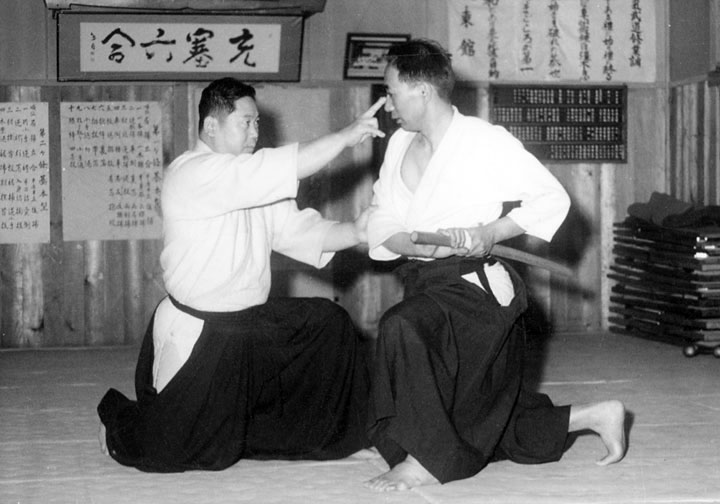 Takeda Tokimune demonstrating a technique against an opponent drawing a short sword at Daitokan dojo, Abashiri, Hokkaido. In this technique, he uses his fingers to attack the opponent’s eyes.